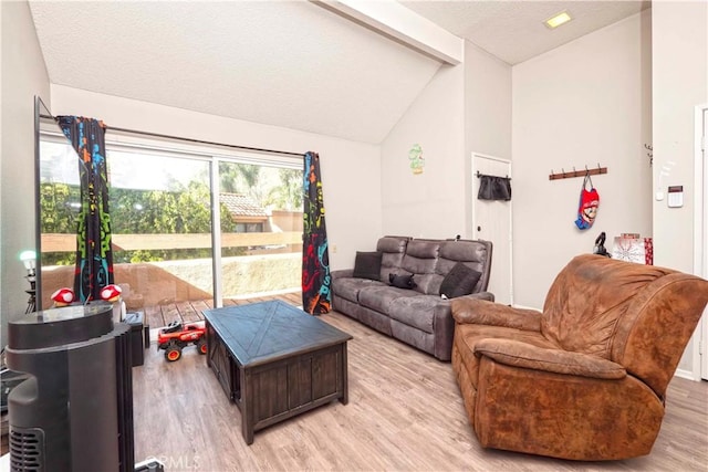 living area with light wood-style flooring, vaulted ceiling, and a textured ceiling