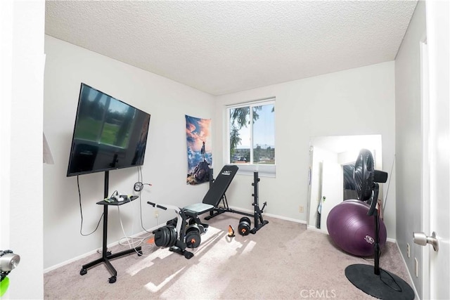 workout room with a textured ceiling, carpet floors, and baseboards