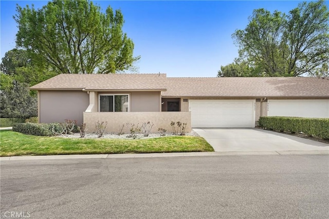 single story home with a garage, concrete driveway, roof with shingles, and stucco siding