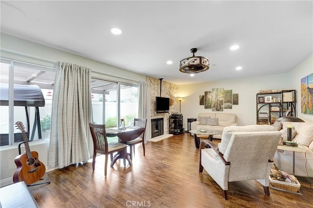 living room with recessed lighting, wood finished floors, and a fireplace