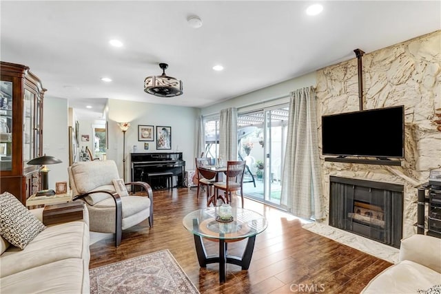 living room featuring a premium fireplace, wood finished floors, and recessed lighting