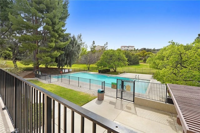 view of swimming pool featuring a yard, a patio area, a fenced in pool, and fence