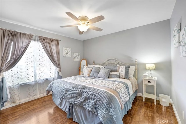 bedroom featuring ceiling fan, wood finished floors, and baseboards