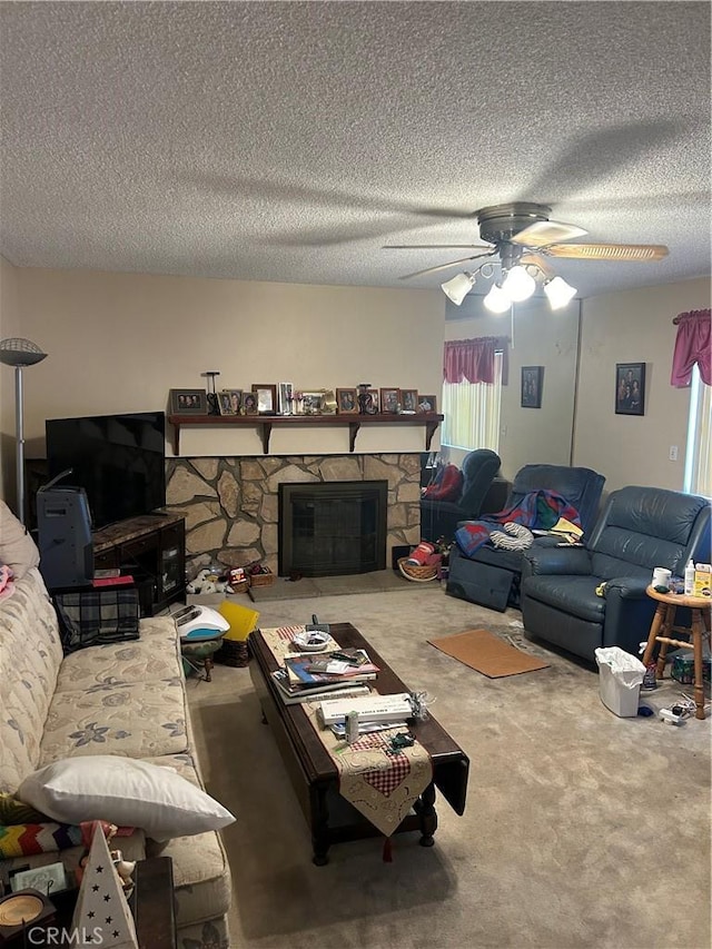 living area featuring carpet, ceiling fan, a textured ceiling, and a stone fireplace