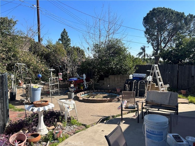 view of patio / terrace with a fenced backyard and a fire pit