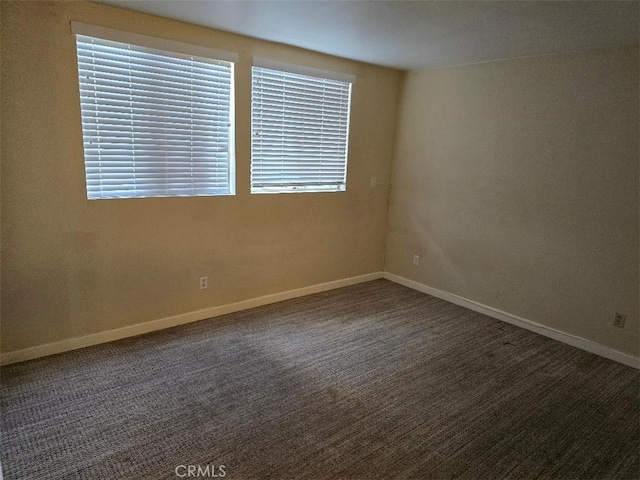 carpeted empty room featuring baseboards