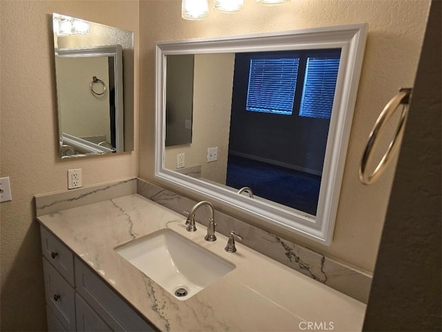 bathroom featuring vanity and a textured wall