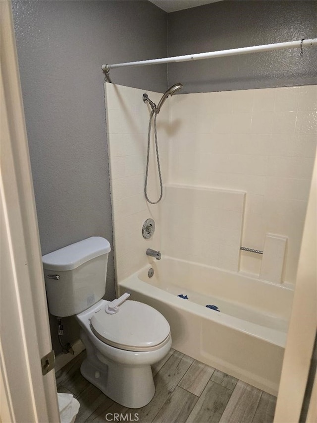 full bath featuring shower / bathing tub combination, toilet, and wood tiled floor