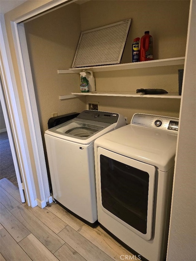 laundry room featuring laundry area, light wood-style floors, and washer and clothes dryer