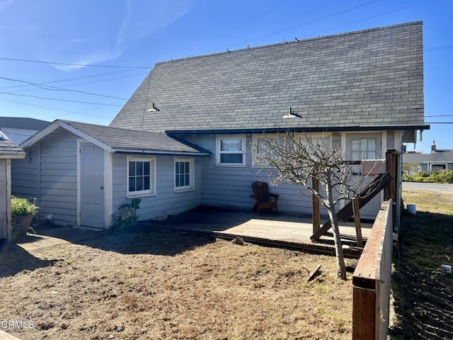 rear view of property featuring roof with shingles