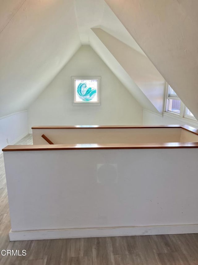 bonus room featuring lofted ceiling and wood finished floors