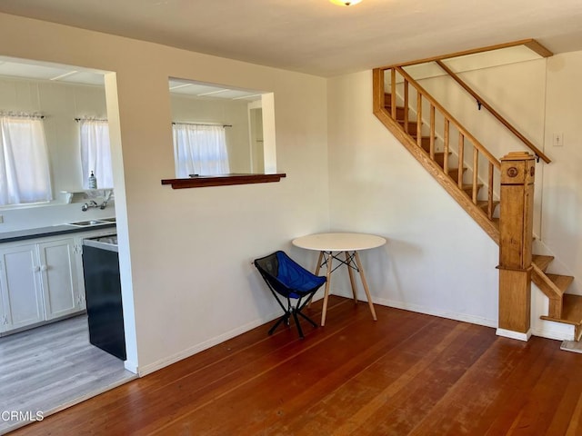 interior space featuring stairs, a sink, wood finished floors, and a wealth of natural light