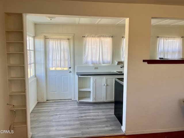 interior space featuring white cabinetry, open shelves, and wood finished floors