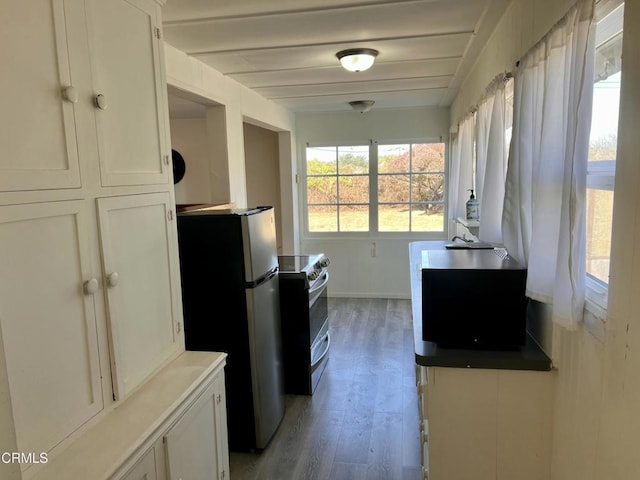 kitchen with white cabinets, light wood-style flooring, baseboards, and stainless steel appliances