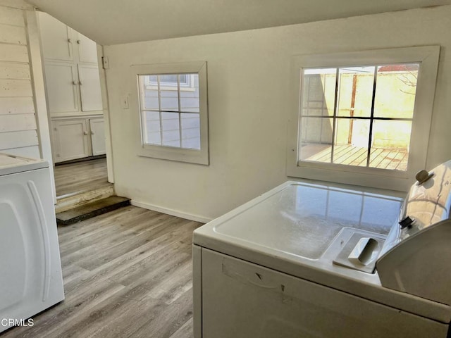 laundry room featuring laundry area, light wood-type flooring, washing machine and dryer, and baseboards