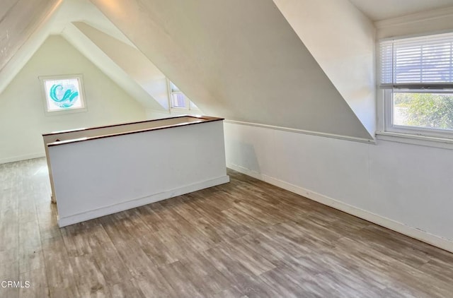 bonus room featuring lofted ceiling, wood finished floors, and baseboards