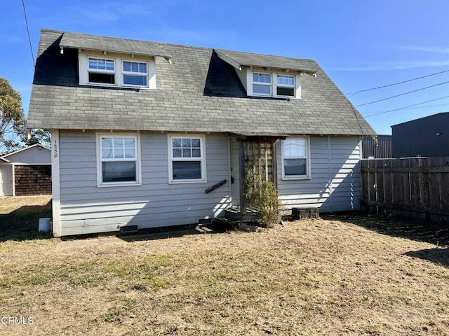 back of property with roof with shingles and fence