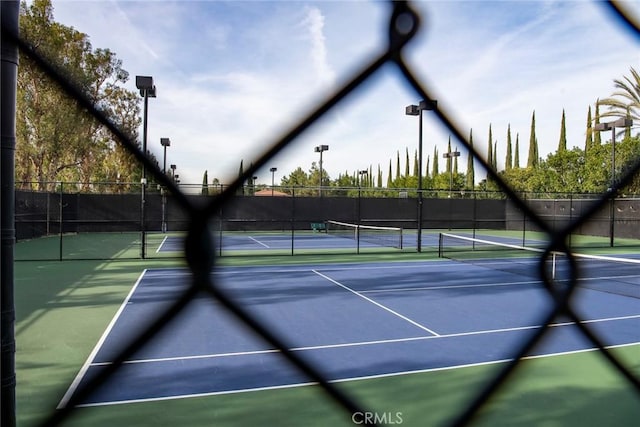 view of tennis court featuring fence