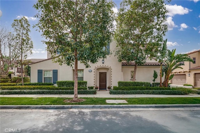 view of front of property featuring a tiled roof and stucco siding