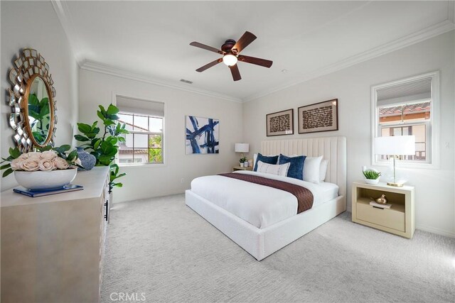 bedroom with ceiling fan, carpet floors, visible vents, and crown molding