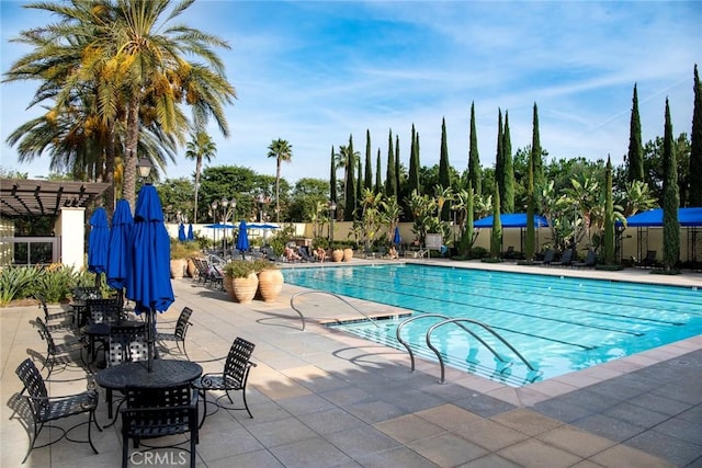 pool with a patio area and fence