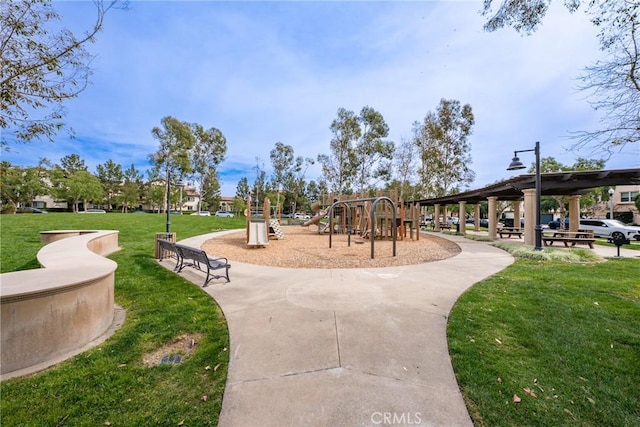 view of property's community with playground community and a yard