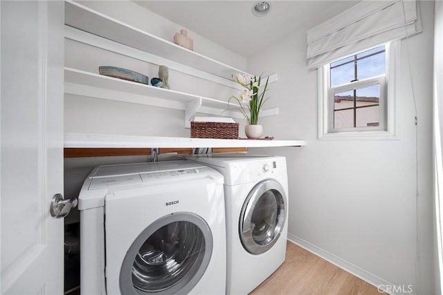 laundry area with laundry area, baseboards, light wood finished floors, and independent washer and dryer