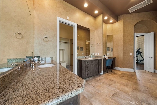 full bath with visible vents, two vanities, and a sink