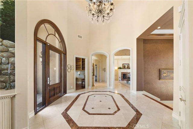 entryway with radiator heating unit, visible vents, baseboards, and a chandelier