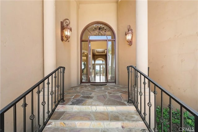 doorway to property with a balcony and stucco siding