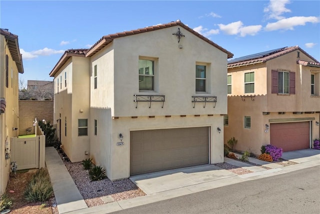 mediterranean / spanish house with a garage, concrete driveway, and stucco siding