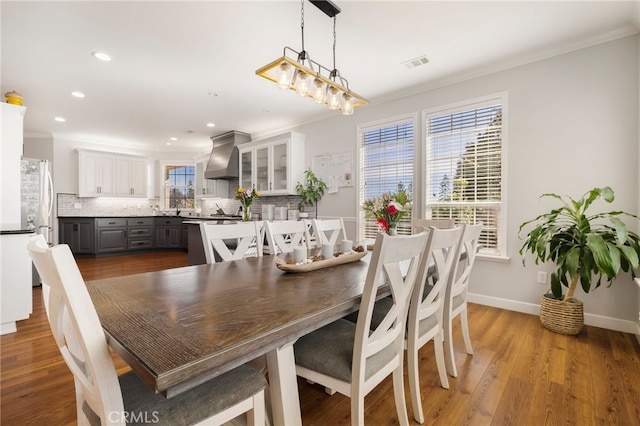 dining space with recessed lighting, visible vents, ornamental molding, wood finished floors, and baseboards