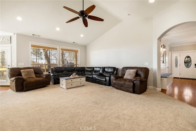 carpeted living room featuring high vaulted ceiling, visible vents, arched walkways, and recessed lighting