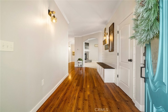 corridor featuring dark wood-style floors, baseboards, and ornamental molding