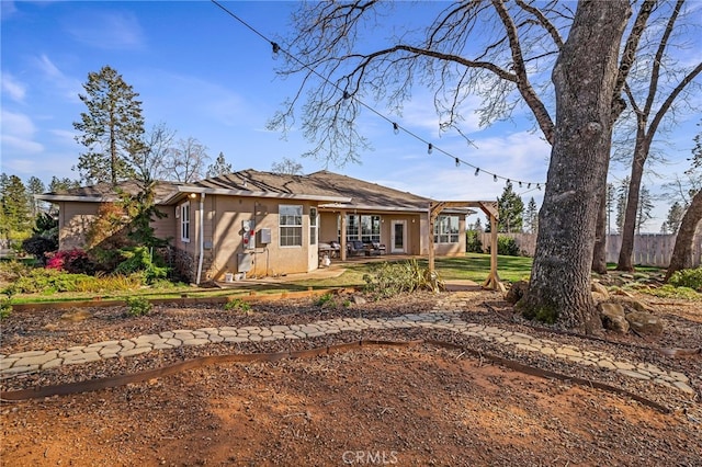 ranch-style home with a patio area, fence, and stucco siding