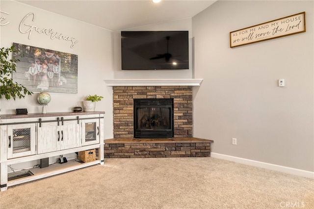 carpeted living room featuring lofted ceiling, a stone fireplace, and baseboards