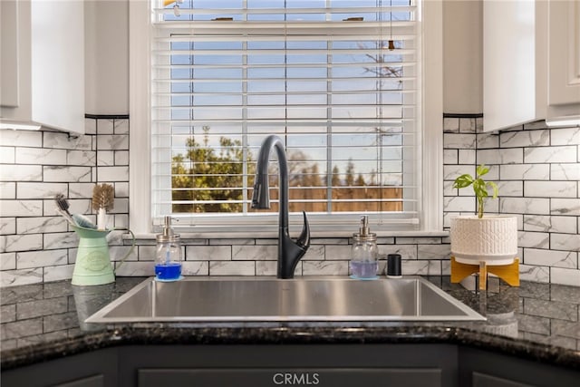 kitchen featuring a wealth of natural light, white cabinetry, and a sink