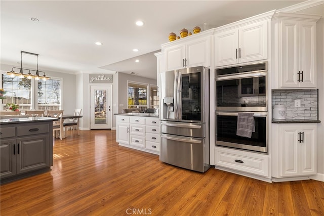 kitchen with light wood finished floors, appliances with stainless steel finishes, gray cabinets, and white cabinets