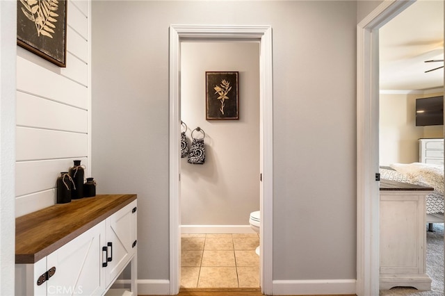 bathroom featuring tile patterned flooring, baseboards, and toilet