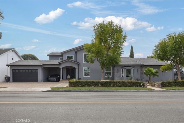 view of front of home featuring an attached garage, driveway, and stucco siding