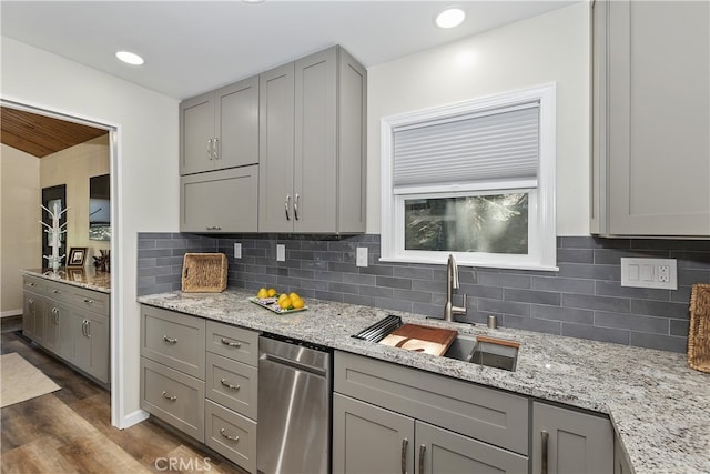 kitchen with tasteful backsplash, dark wood-style flooring, a sink, and gray cabinetry