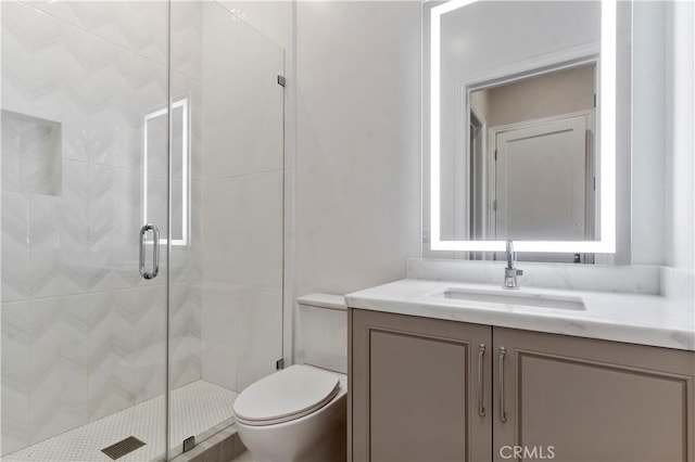 full bath with vanity, a shower stall, and toilet