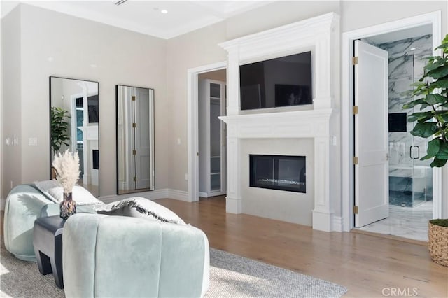 living area featuring wood finished floors, a glass covered fireplace, and recessed lighting