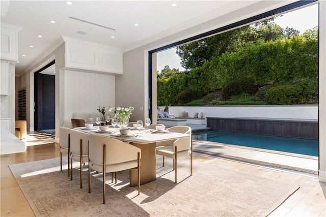 dining area with a healthy amount of sunlight, recessed lighting, wood finished floors, and crown molding