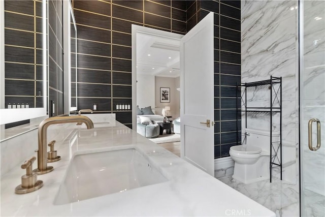 full bathroom featuring marble finish floor, tile walls, toilet, a sink, and a shower stall