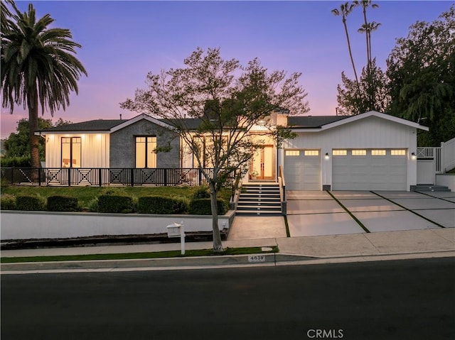 view of front of house with a garage, driveway, and stairway