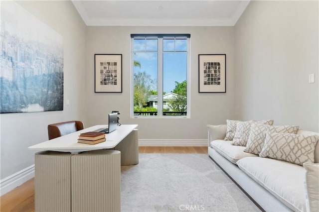 office space with ornamental molding, light wood-type flooring, and baseboards