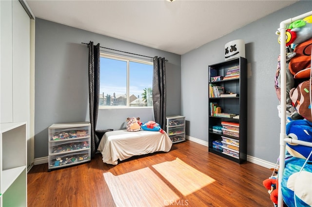 bedroom featuring baseboards and wood finished floors