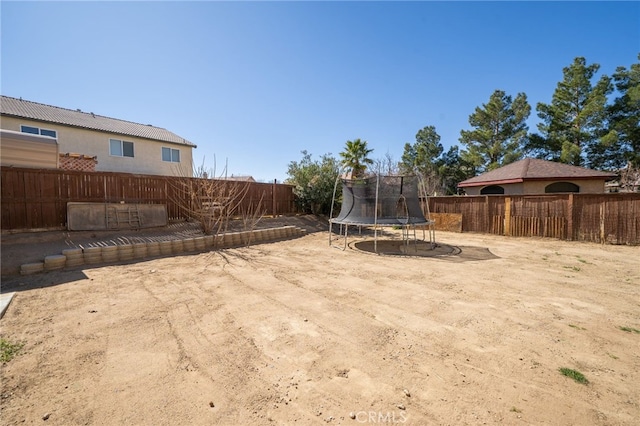 view of yard featuring a fenced backyard and a trampoline