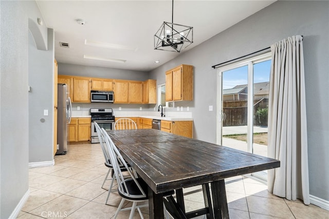 kitchen with light tile patterned floors, baseboards, visible vents, stainless steel appliances, and light countertops